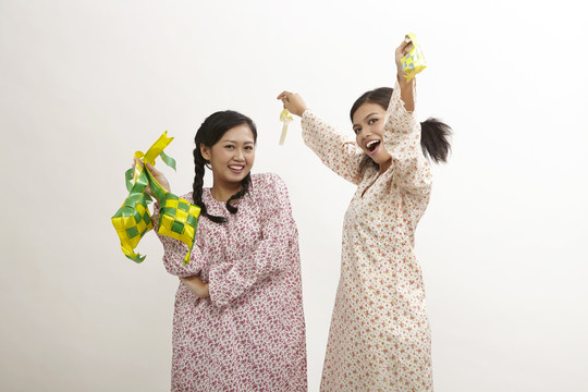 两名马来妇女身穿白底白衣，手持紧身衣