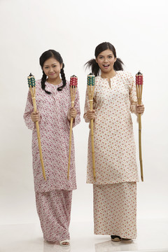 两名马来妇女身穿白底白衣，手持佩利塔