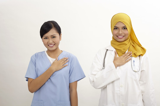 亚洲护士和医生，白色背景上有欢迎手势