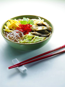 马来西亚菜-一碗阿萨姆拉克萨，旁边放一双红筷子
