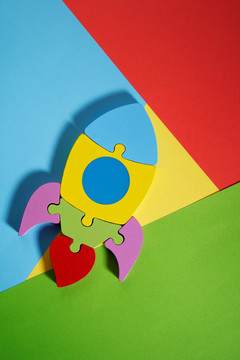 彩色木制拼图，儿童玩具的形式，火箭，在一个彩色的背景