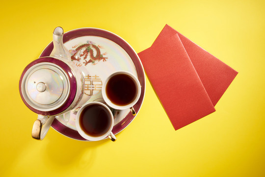 中国传统婚礼上使用的茶壶和茶杯，带有中国标志，寓意幸福。翻译：双喜临门