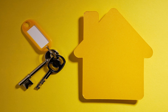 黄色纸房子和钥匙，黄色背景上有标签