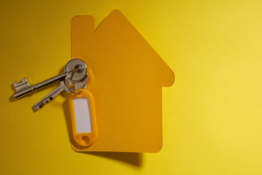 黄色纸房子和钥匙，黄色背景上有标签