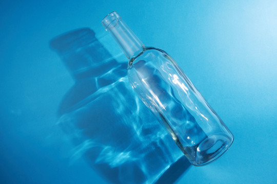 蓝色背景上的空玻璃瓶
