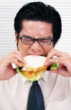 一个男人咬着一个有信用卡的三明治