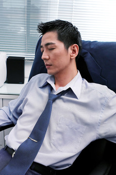 穿蓝衬衫的人靠在椅子上睡觉