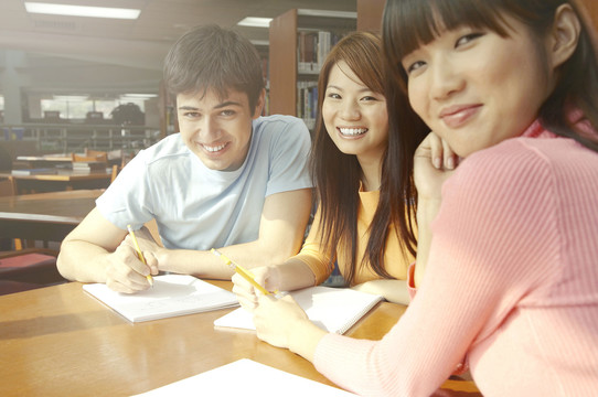 大学生在图书馆学习时对着镜头微笑
