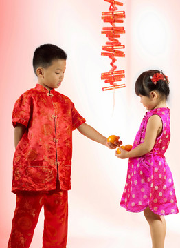 一个男孩和他的妹妹分享他的桔子