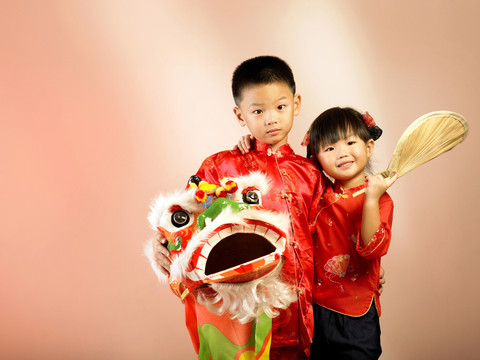 两个孩子手里拿着舞狮玩具一起拍照