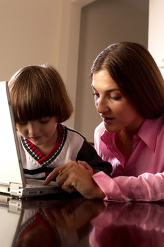 教儿子如何使用笔记本电脑的女人