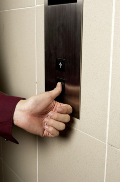 用手指按电梯的向下按钮