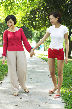 母女俩在公园里散步时手牵着手