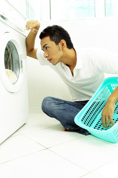 男人看着旋转的洗衣机