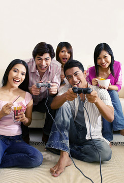 一群男女在家里玩电子游戏机