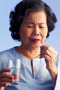 一位老妇人吃药的摄影棚镜头