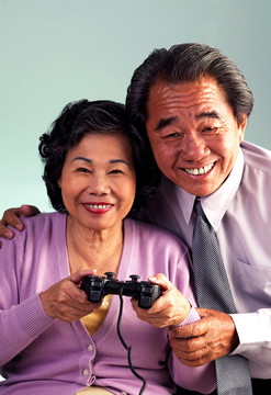 一对老夫妇玩游戏机的摄影棚照片