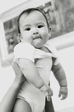 一个可爱的婴儿被举起的黑白照片