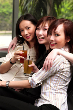 三个女人在咖啡馆里对着镜头摆姿势