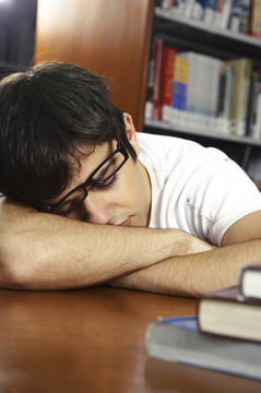 在图书馆睡觉的戴着眼罩的年轻人