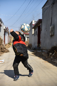 乡村踢足球的男孩