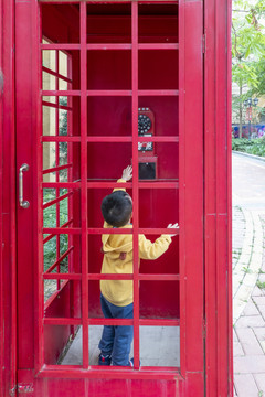一个小孩在电话亭里