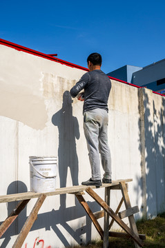 粉刷围墙的建筑工人