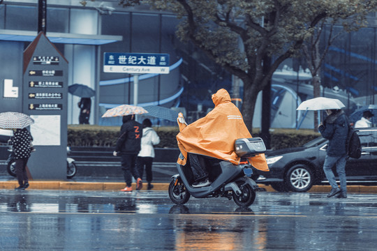 雨中骑电动车的人