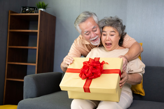 亚洲老年夫妇，家中有礼品盒，周年纪念或圣诞节假期概念