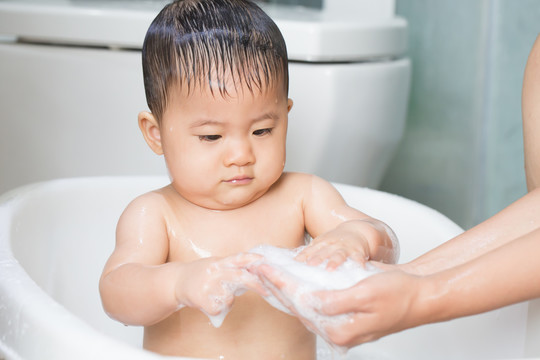 婴儿在洗澡时玩肥皂泡