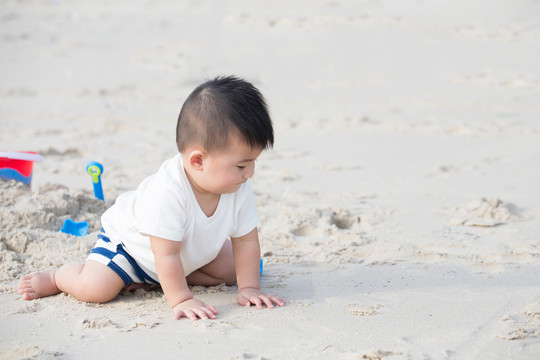 小男孩在热带海滩上玩沙子