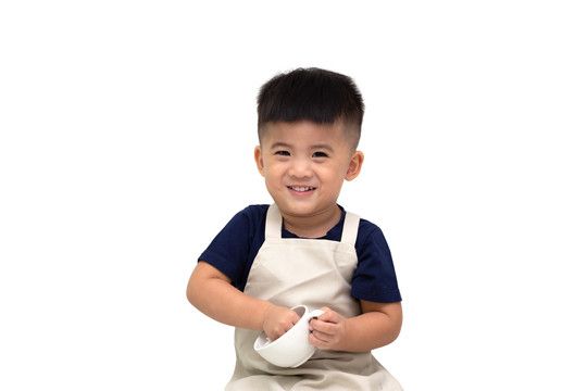 快乐的亚洲咖啡师男孩微笑着，举着咖啡杯，背景是白色的