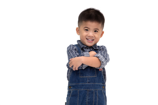亚洲小男孩的画像，双臂交叉，微笑隔离在白色背景上，微笑着看着相机，快乐的感觉概念