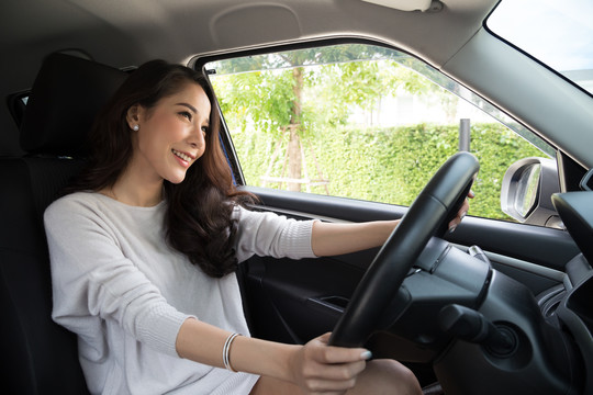 亚洲女性在开车旅行的过程中，带着快乐的积极表情开怀大笑，人们享受着欢笑和放松的快乐女性公路旅行度假理