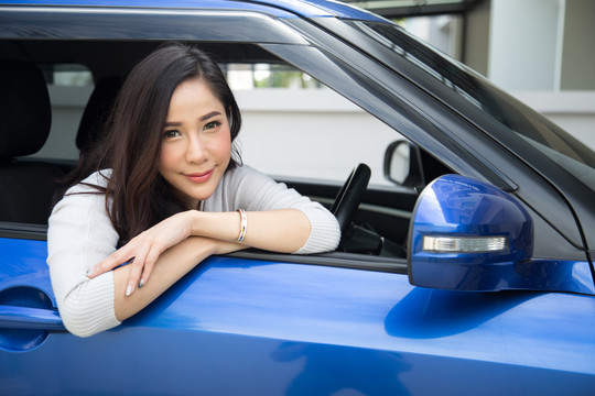 坐在蓝色汽车里的亚洲女人