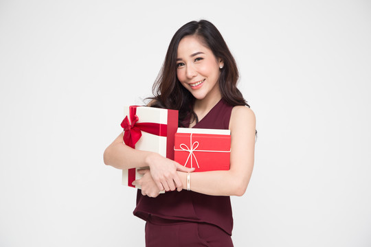 亚洲美女微笑拥抱白色背景上的礼品盒
