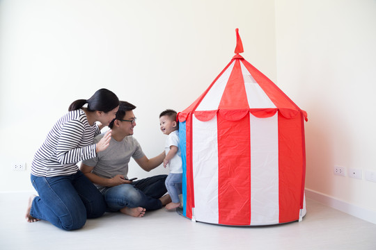 快乐的亚洲家庭和儿子在家里的房间里玩城堡帐篷，一起开心，微笑
