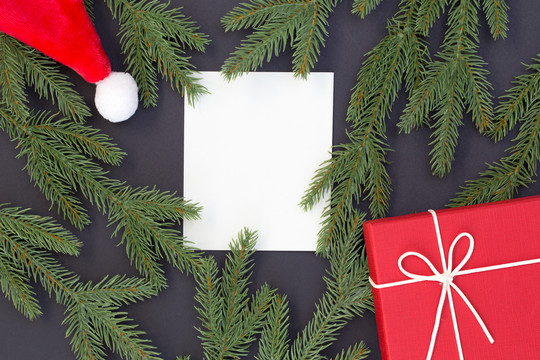 圣诞和新年快乐构图的俯视图、礼品盒、松果、黑色背景上的冷杉枝以及文本的复印空间白皮书