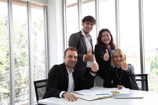 成功的商务人士竖起大拇指，面带微笑，完美的合作团队理念