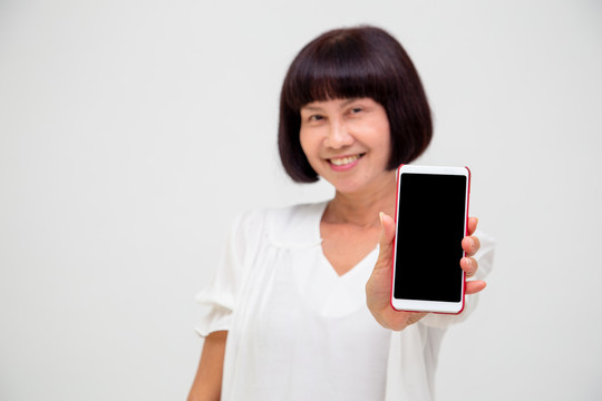 亚洲资深沃万在白色背景上展示或展示手机应用程序的肖像