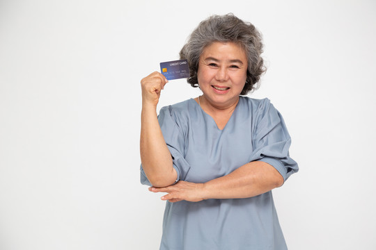 手持信用卡并在白色背景上单独展示的亚洲高级女性肖像