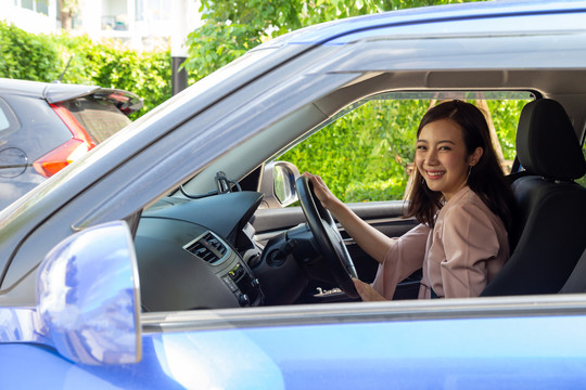 亚洲女性在开车旅行的过程中，带着快乐的积极表情开怀大笑，人们享受着欢笑的交通和轻松快乐的女性路途度假