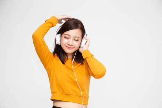 智能手机播放列表歌曲应用程序中的亚洲女性带耳机听音乐，时髦少女概念