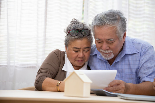 亚洲老年夫妇签订购房合同、房地产贷款和住房金融概念