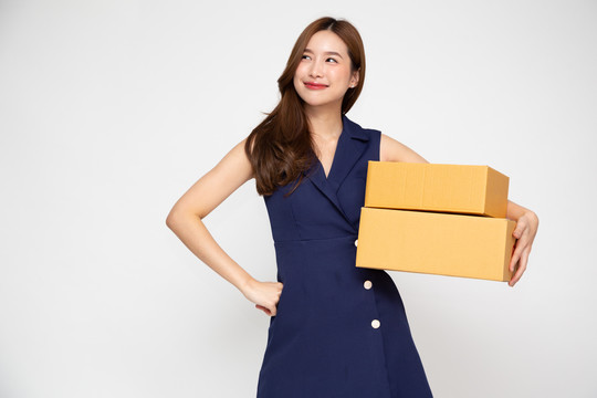 快乐的亚洲女人微笑着拿着白色背景上隔离的包裹盒，快递和运输服务理念
