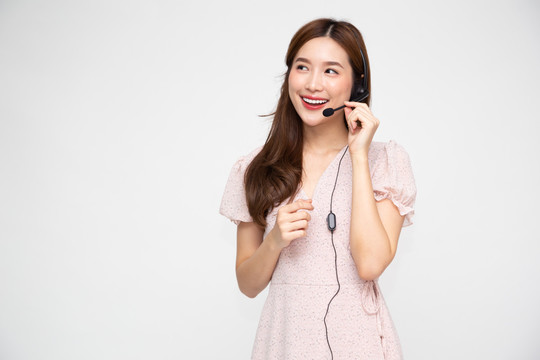 年轻的亚洲女性呼叫中心被隔离在白色背景下，电话销售或客户服务运营商的耳机概念