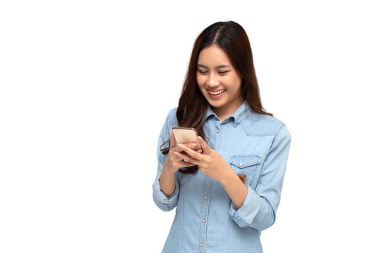 快乐的亚洲年轻女性使用智能手机，在白色背景下通过手机聊天应用程序收到好消息
