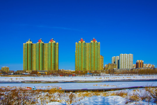 高层住宅建筑群与雪地河道蓝天