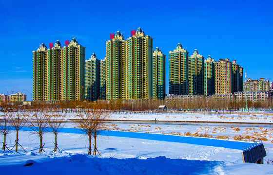 高层住宅建筑群与雪地河道树木