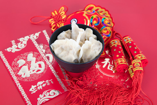 红背景上的一碗饺子和红包及装饰